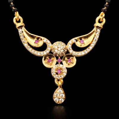 Celebrate your union with a piece that radiates regal charm and intricate artistry. This gold-toned Mangalsutra features a stunning, wing-inspired centerpiece accented by vibrant ruby-hued stones, perfectly blending traditional significance with a high-glamour aesthetic.