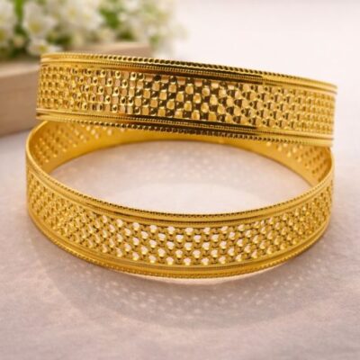 Celebrate the intricate beauty of artisanal gold-work with this pair of stunning gold-toned bangles. Featuring a sophisticated openwork design and a rich, textured finish, these pieces offer a bold yet airy aesthetic that perfectly bridges the gap between traditional and modern luxury.