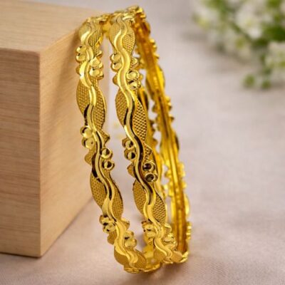 Celebrate the grace of movement with this pair of stunning gold-toned bangles. Featuring a rhythmic, scalloped silhouette and a rich interplay of textures, these pieces offer an organic and feminine aesthetic that beautifully reimagines traditional gold craftsmanship.