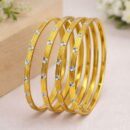 Elevate your signature style with a masterclass in linear elegance. This set of four gold-toned bangles features a sophisticated architectural design, blending rhythmic ribbing with radiant accents for a look that is both structured and luminous.