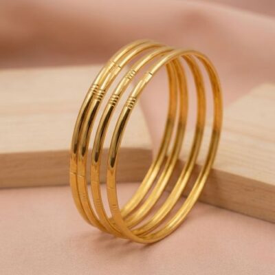 Embrace the beauty of "quiet luxury" with this set of four gold-toned bangles. Featuring a masterclass in understated elegance, these pieces blend a sleek, high-mirror finish with subtle architectural ribbing for a foundation piece that never goes out of style.