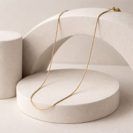 Embrace the peak of "quiet luxury" with this impeccably crafted gold-toned snake chain. Featuring a masterclass in fluid movement and high-shine surfaces, this piece offers a sleek, ultra-fine silhouette that serves as the ultimate versatile foundation for your jewelry collection.