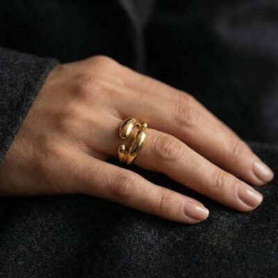 Embrace the peak of modern sculptural design with this impeccably crafted gold-toned open ring. Featuring a masterclass in organic fluidity and high-mirror light play, this piece offers a bold, "liquid metal" silhouette that serves as the ultimate statement of contemporary elegance.