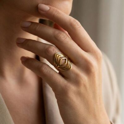 Embrace the peak of architectural jewelry design with this impeccably crafted gold-toned statement ring. Featuring a masterclass in linear symmetry and openwork artistry, this piece offers a bold, tiered silhouette that serves as the ultimate expression of modern, structured elegance.