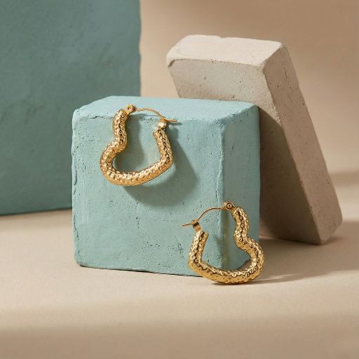 Embrace the peak of contemporary romantic design with these impeccably crafted gold-toned hoop earrings. Featuring a masterclass in organic texture and bold architectural form, this pair offers a sophisticated "sculpted-heart" silhouette that serves as the ultimate statement of modern luxury.