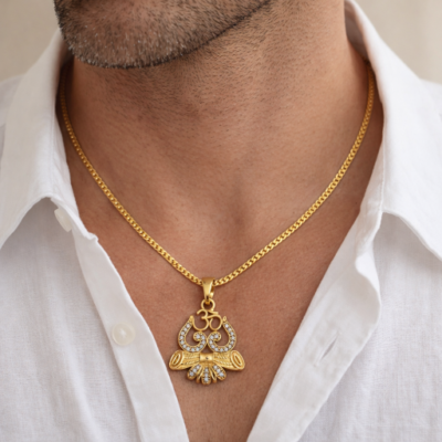 Embrace a powerful symbol of protection and spiritual energy with this masterfully crafted gold-toned pendant. This piece artfully combines the sacred symbols of Lord Shiva—the Trishul (Trident), the Damru (Drum), and the Om—into a singular, radiant expression of faith and strength.